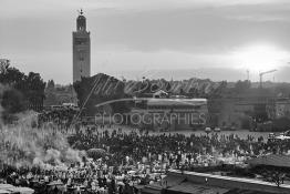 Image du Maroc Professionnelle de  Le Soleil se couche la foule envahi la fameuse Place Jemaa El Fana qui se métamorphose en un gigantesque restaurant en plein air grâce aux nombreux stands et gargotes qui s'y installent sur ce lieu mythique au centre de la médina de Marrakech. Au fond le minaret de la Koutoubia, Samedi 26 Février 2005. (Photo / Abdeljalil Bounhar)

